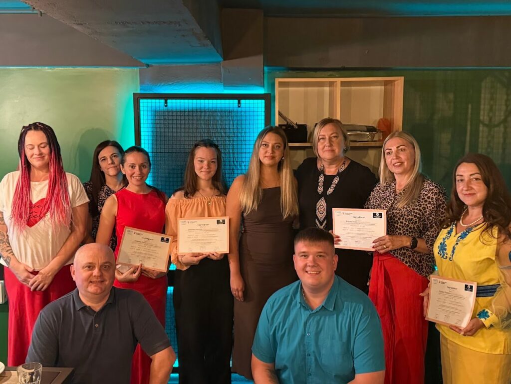 A group poses together, with several participants holding certificates.